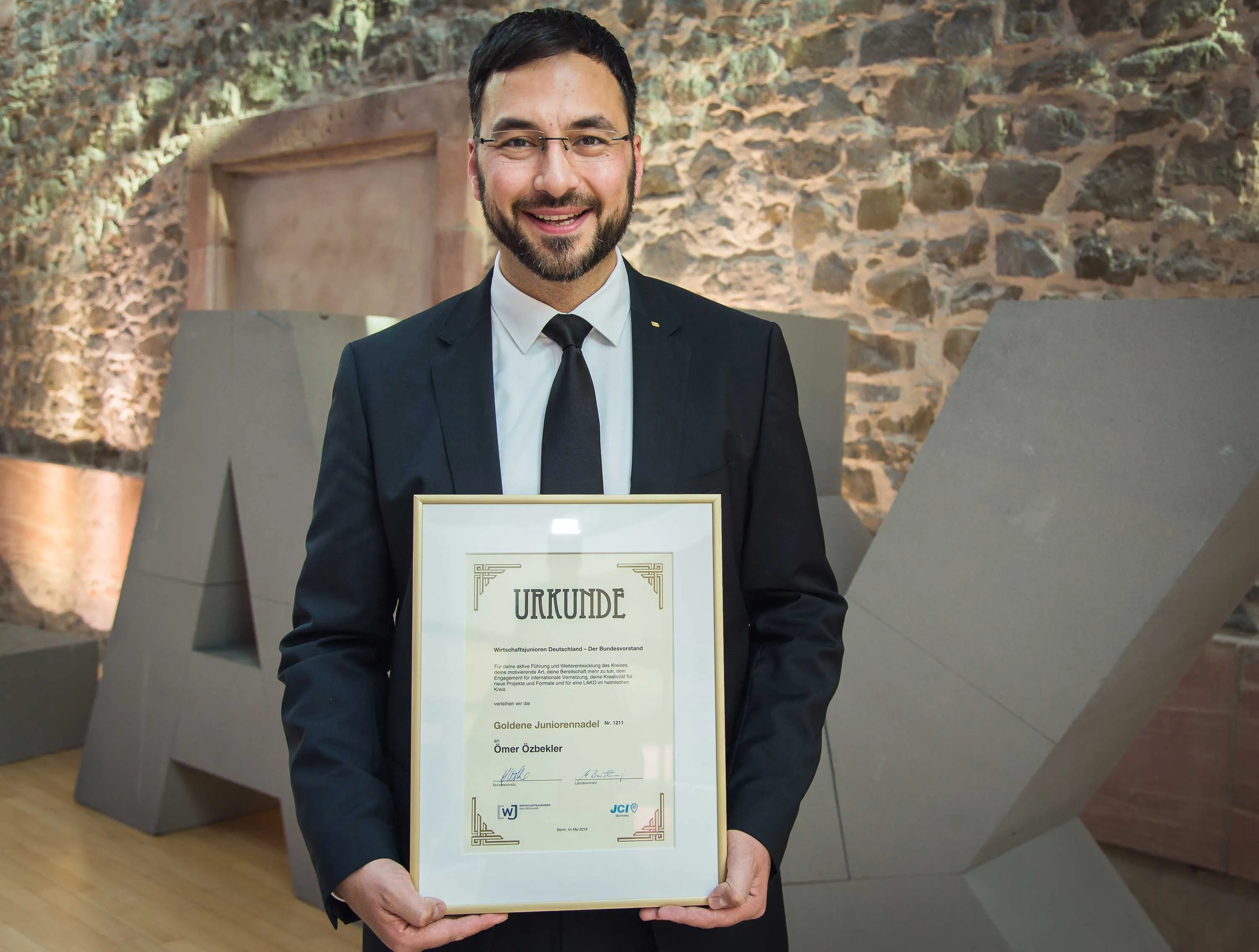 Ömer Özbekler bei der Verleihung der Urkunde Wirtschaftsjunioren Deutschland - Der Bundesvorstand - Goldene Juniorennadel